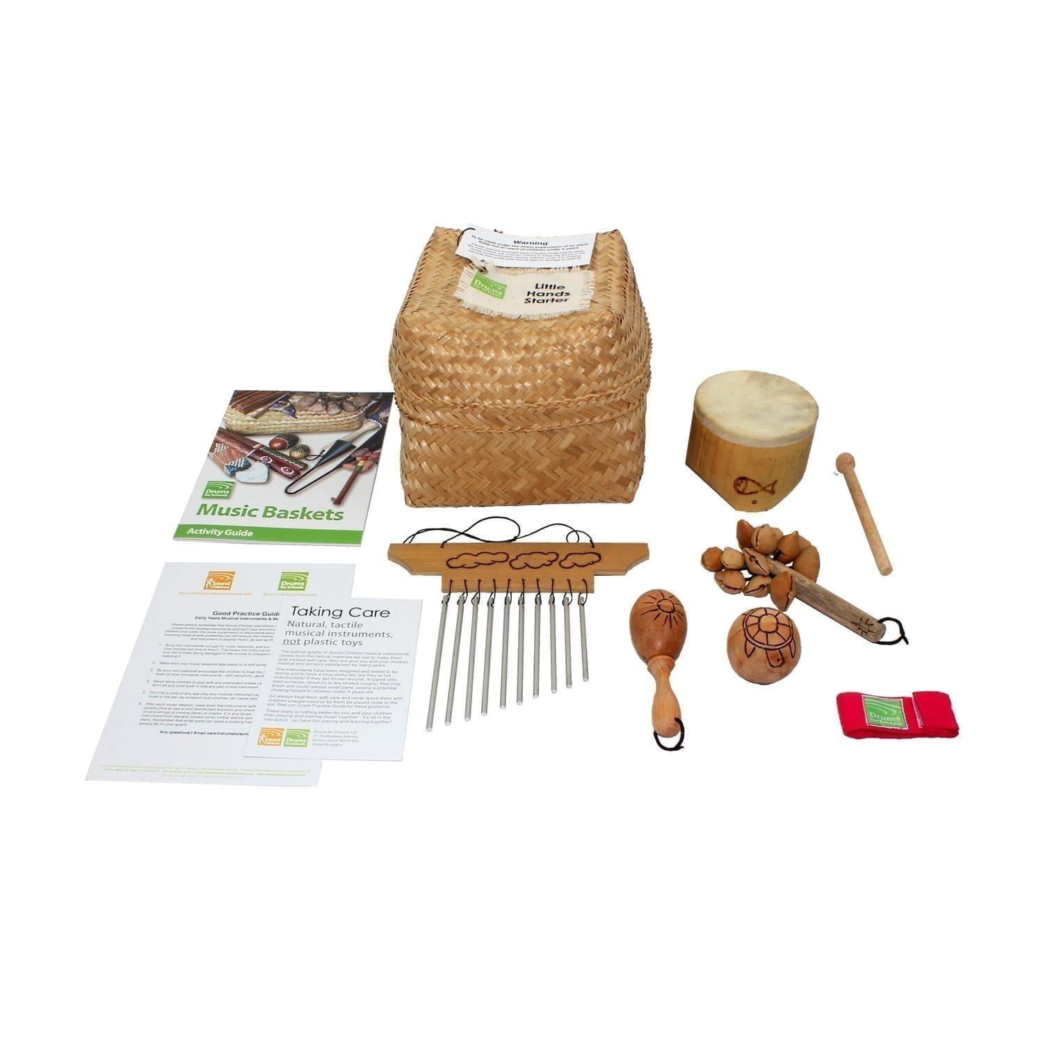 Little Hands Starter Basket - 5 Instruments, with the contents laid out flat outside of the basket, include one Bamboo Mini Drum, one Ball Shaker - 5cm, Early Years - Early Years, one Wind Chime - Early Years, one Kenari Shaker - Early Years, one Music Bracelet - XS, one Egg on Stick - Small - 5cm, Early Years.