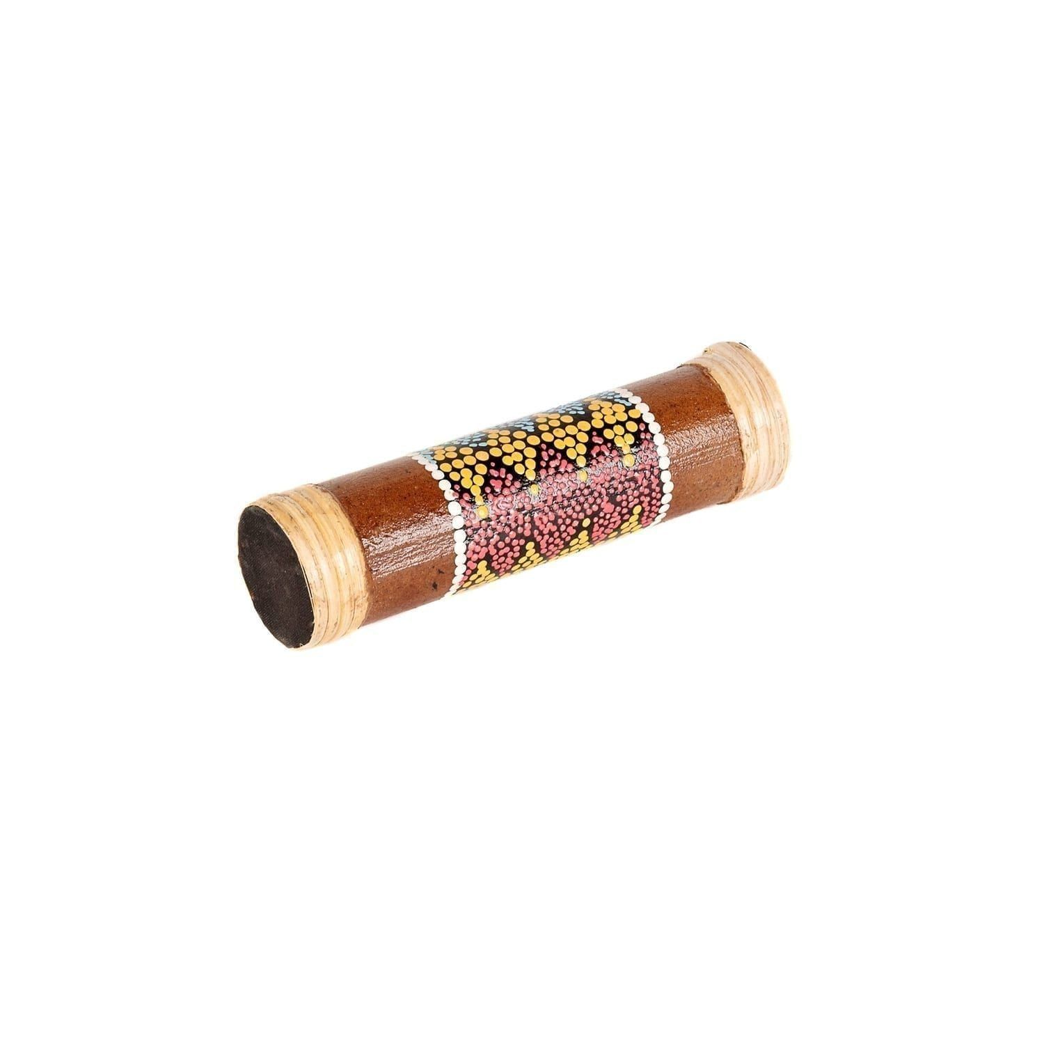 This is a product image of the Rainstick - 20cm, bamboo, painted. It is a wooden tube that has been decorated in the middle third by paint dots, closely placed together to make a consistent pattern. The instrument is laying flat and angled from bottom left to top right.
